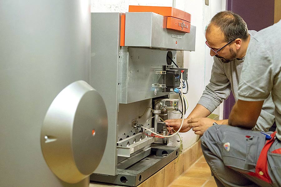 Das Bild zeigt zwei Handwerker bei der Wartung einer Heizungsanlage und dient als Titelbild für das Thema „Wärmeversorgung: Herausforderung für die M&A-Beratung“